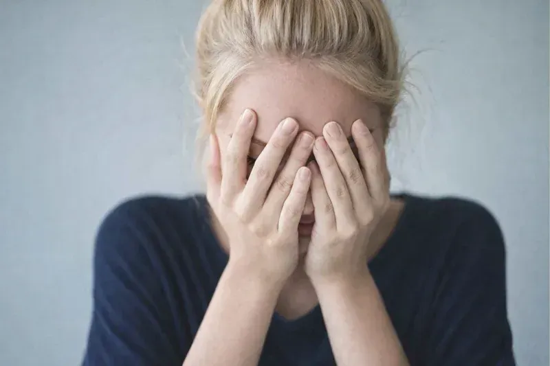 Woman covering face with hands representing the stigma and shame of addiction.At MEDIVIRA, compassionate stigma-free addiction and mental health care is available in-person and via telehealth — your privacy is always protected