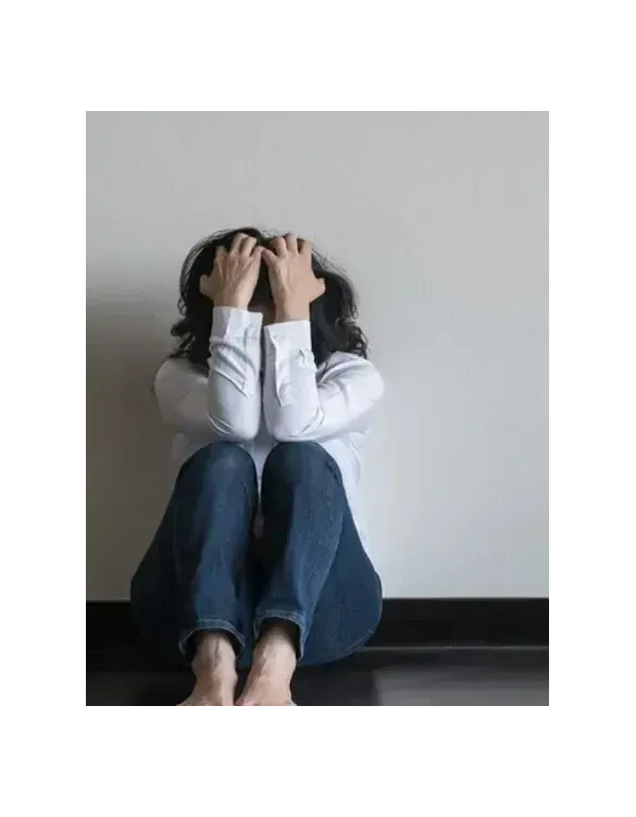 Woman sitting against a wall with head in hands experiencing opioid withdrawal symptoms — Medivira offers compassionate MAT and Suboxone treatment for opioid use disorder in Frisco, TX