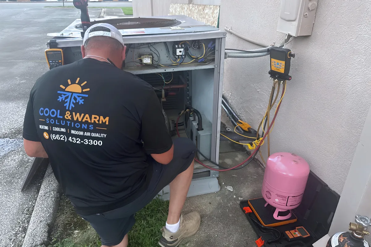 Commercial HVAC technician servicing a heating and cooling system for a business in Tupelo, Mississippi.