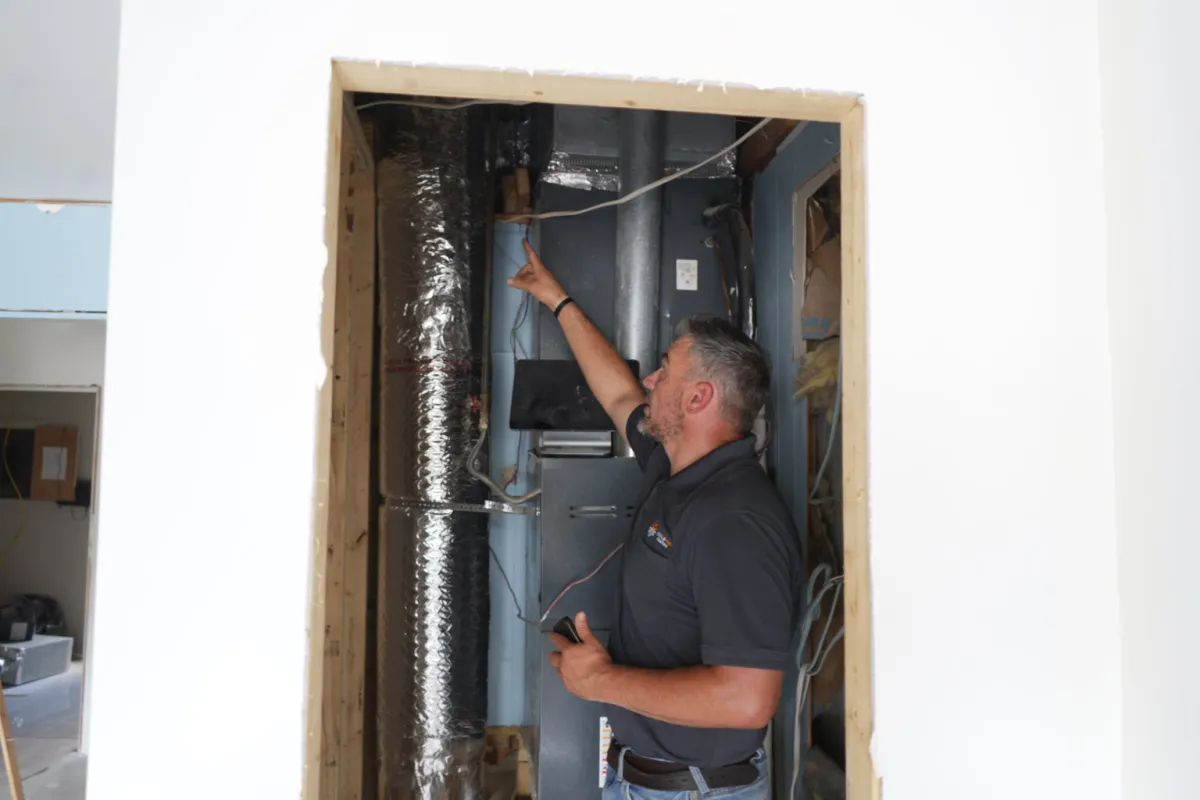 HVAC technician performing preventative maintenance on a residential heating and air conditioning system in Tupelo, Mississippi.