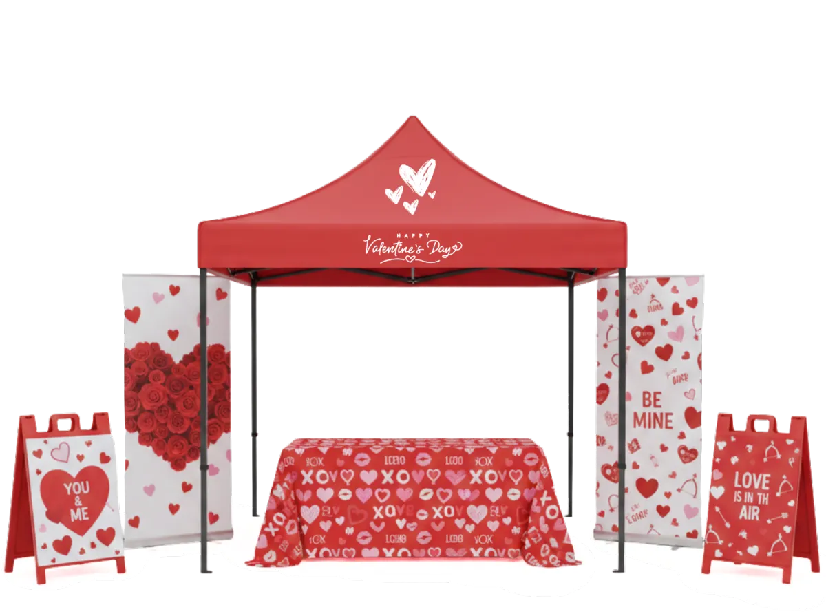 Custom printed Valentine's Day event display by WallaSigns, featuring a red "Happy Valentine's Day" canopy tent, matching heart-patterned table throw, vertical banners, and A-frame sidewalk signs.