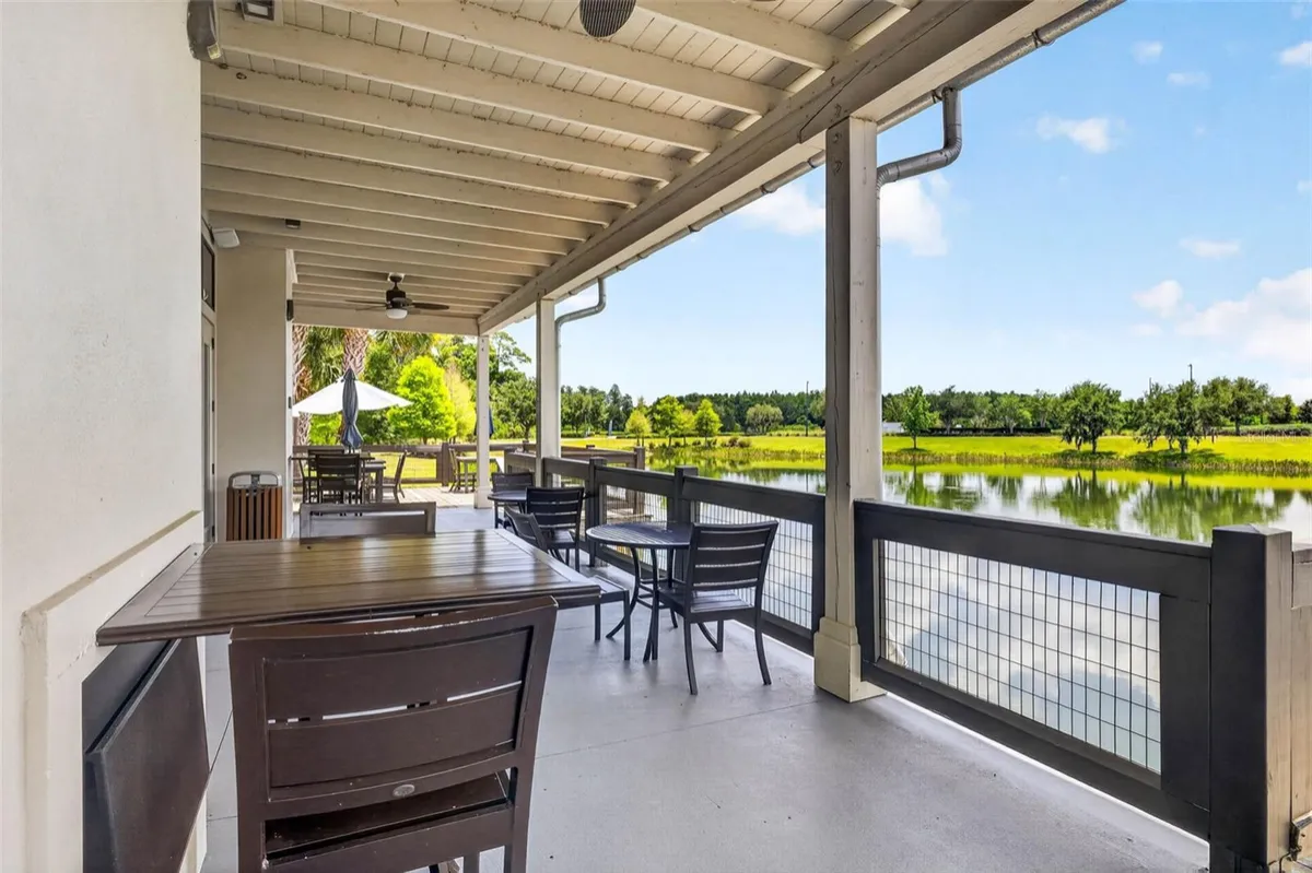 Covered clubhouse patio overlooking a pond and tree line in Bexley