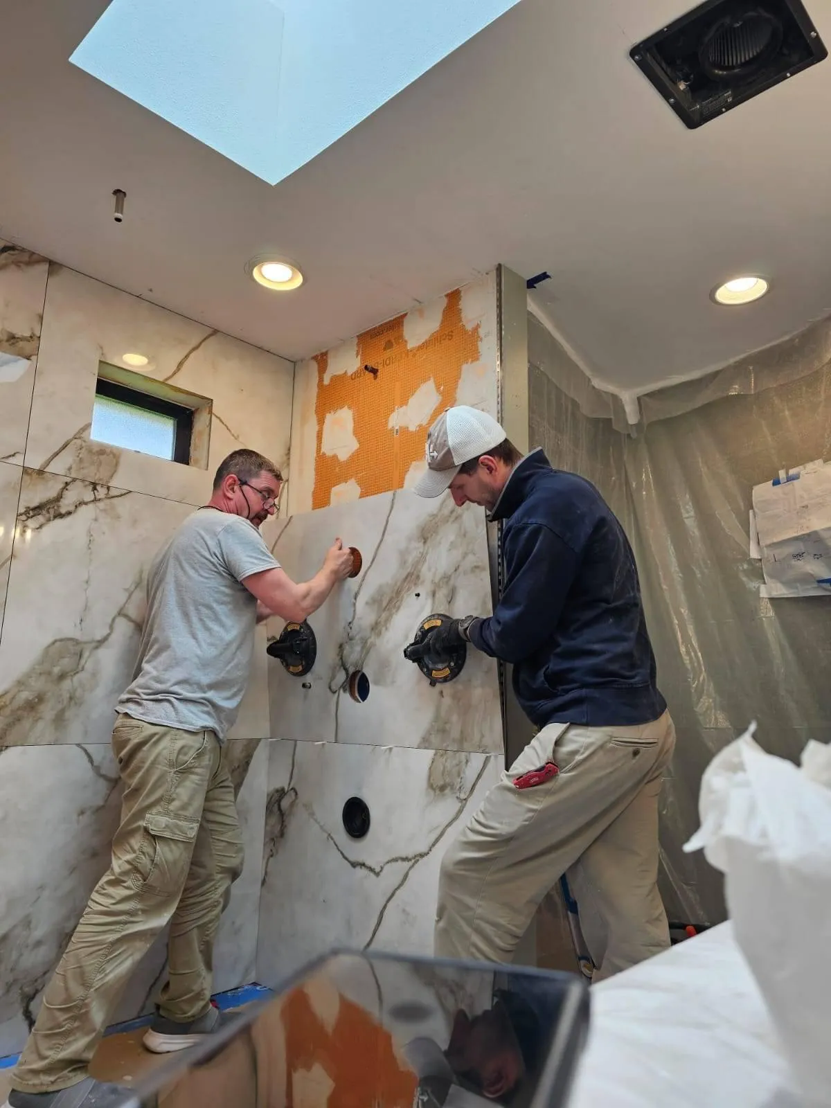 Two Construction Workers Putting Up Marble