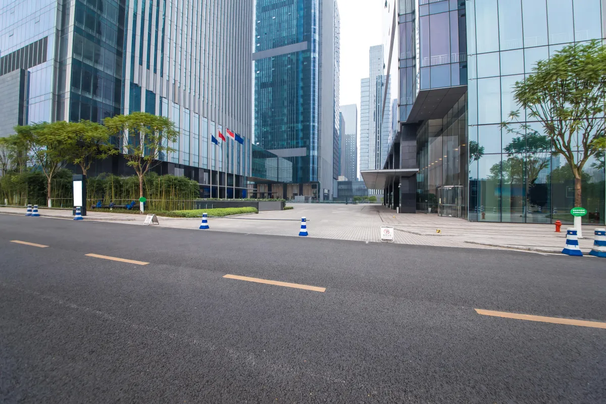 person in black and white jacket holding umbrella walking on pedestrian lane during daytime