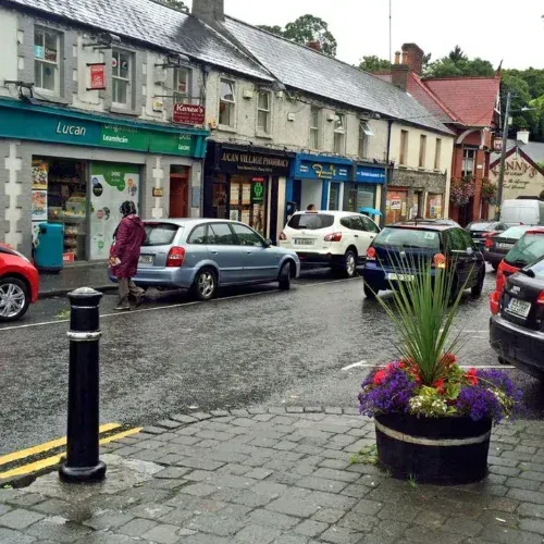 Lucan village main street with shops and parked cars, an area served by Quick Fix Removals Dublin