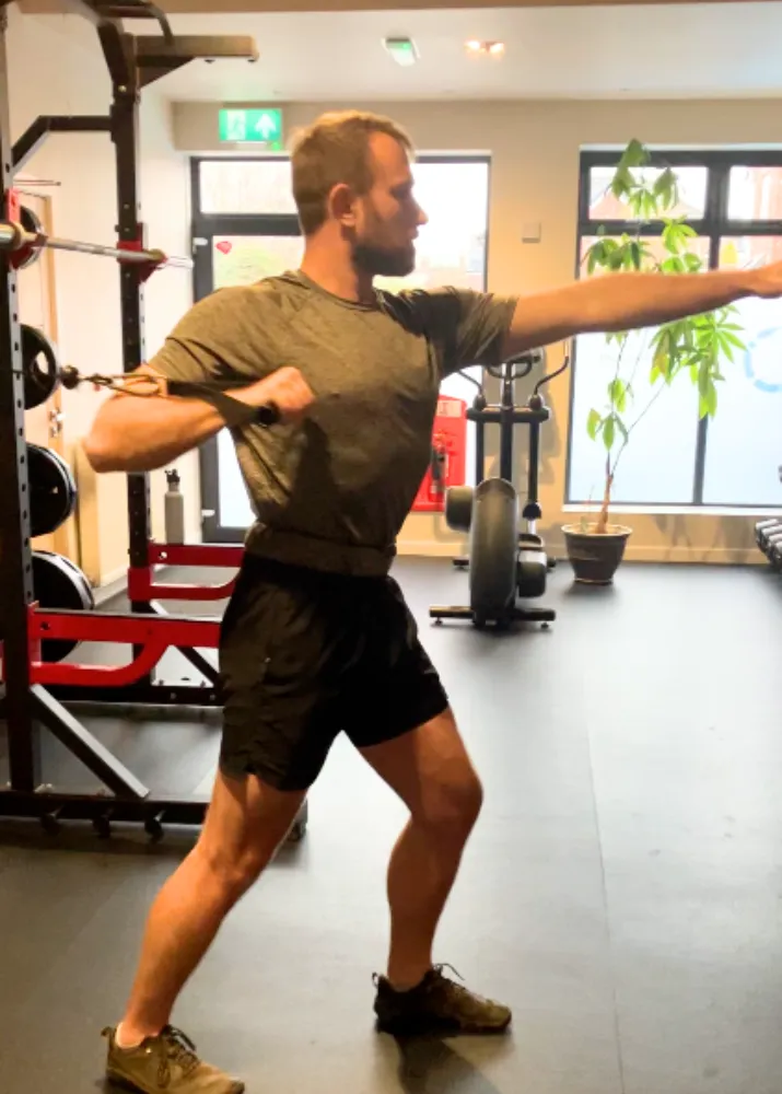 A client doing a cable push exercise