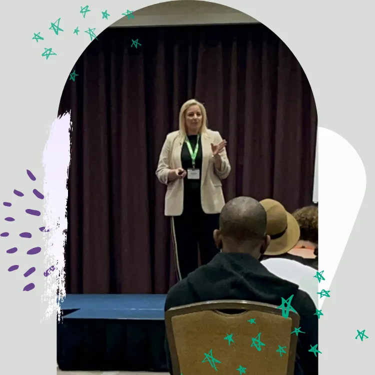 Justine speaking on stage at an event 
