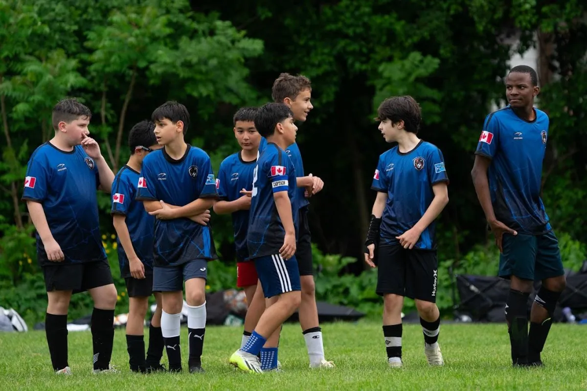 Kids playing soccer with a coach during practice