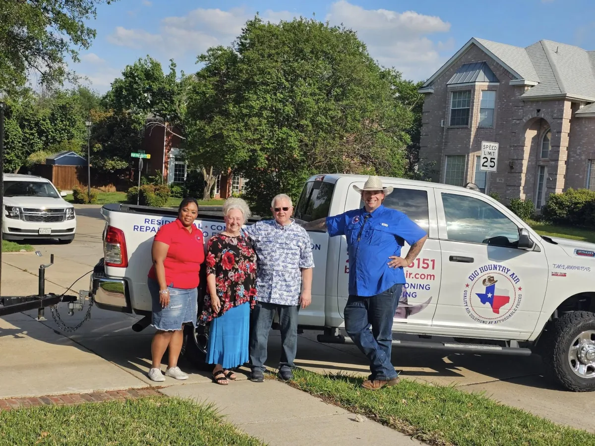Tiffany and Blake from Big Kountry Air standing with two happy North Dallas customers in front of branded HVAC service truck in a residential neighborhood.