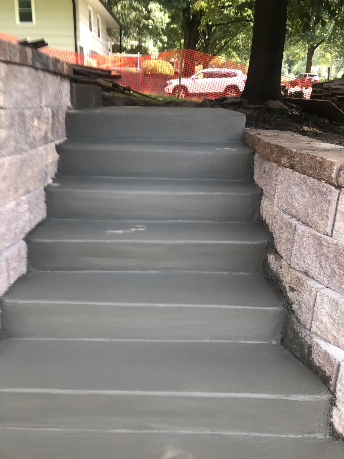 Concrete retaining wall installation in Kansas City backyard with drainage system and clean finish