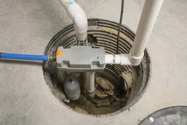 Installed sump pump system and interior French drain for basement waterproofing in Kansas City home