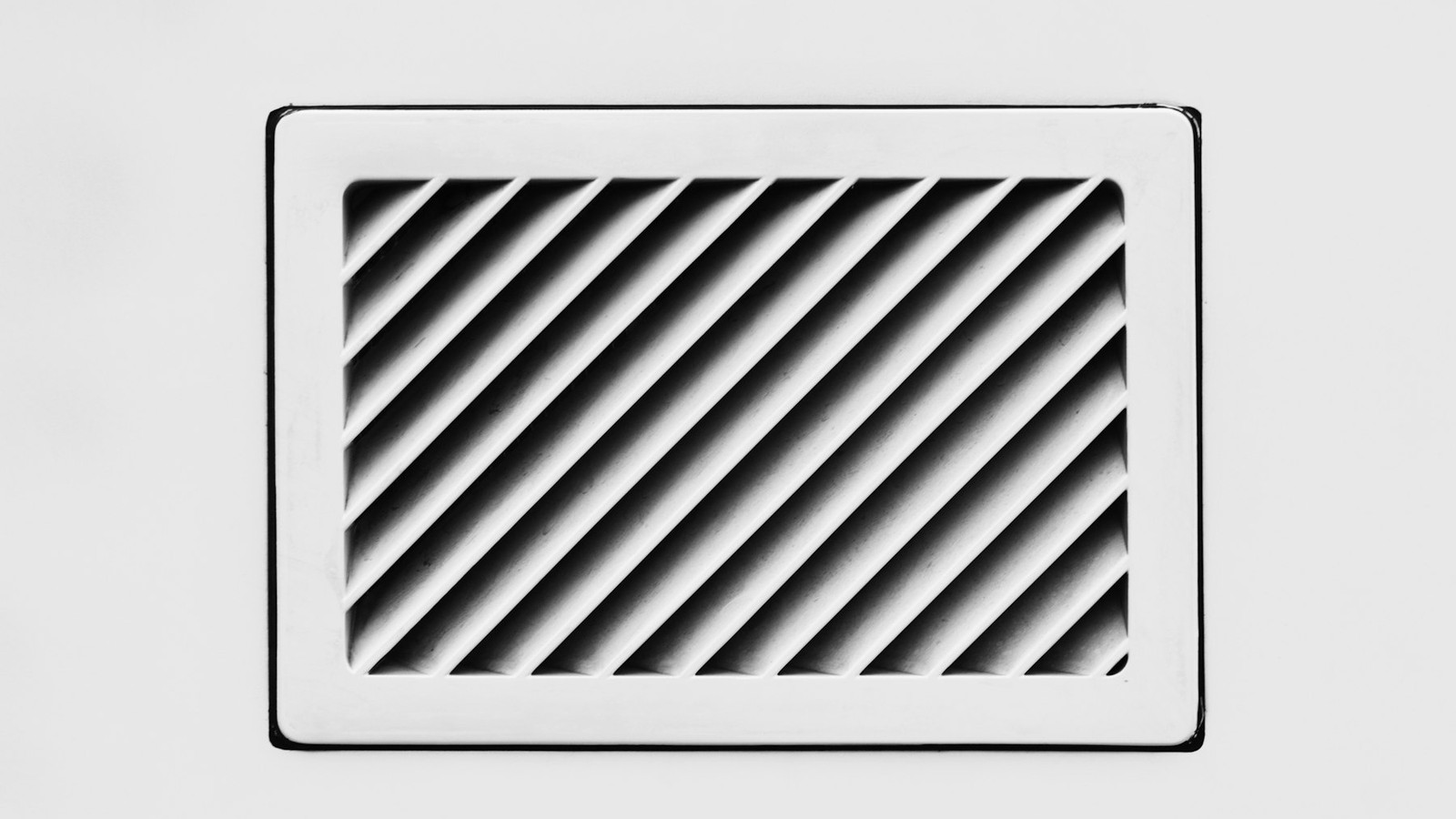 Close-up black and white photo of a residential air vent grille
