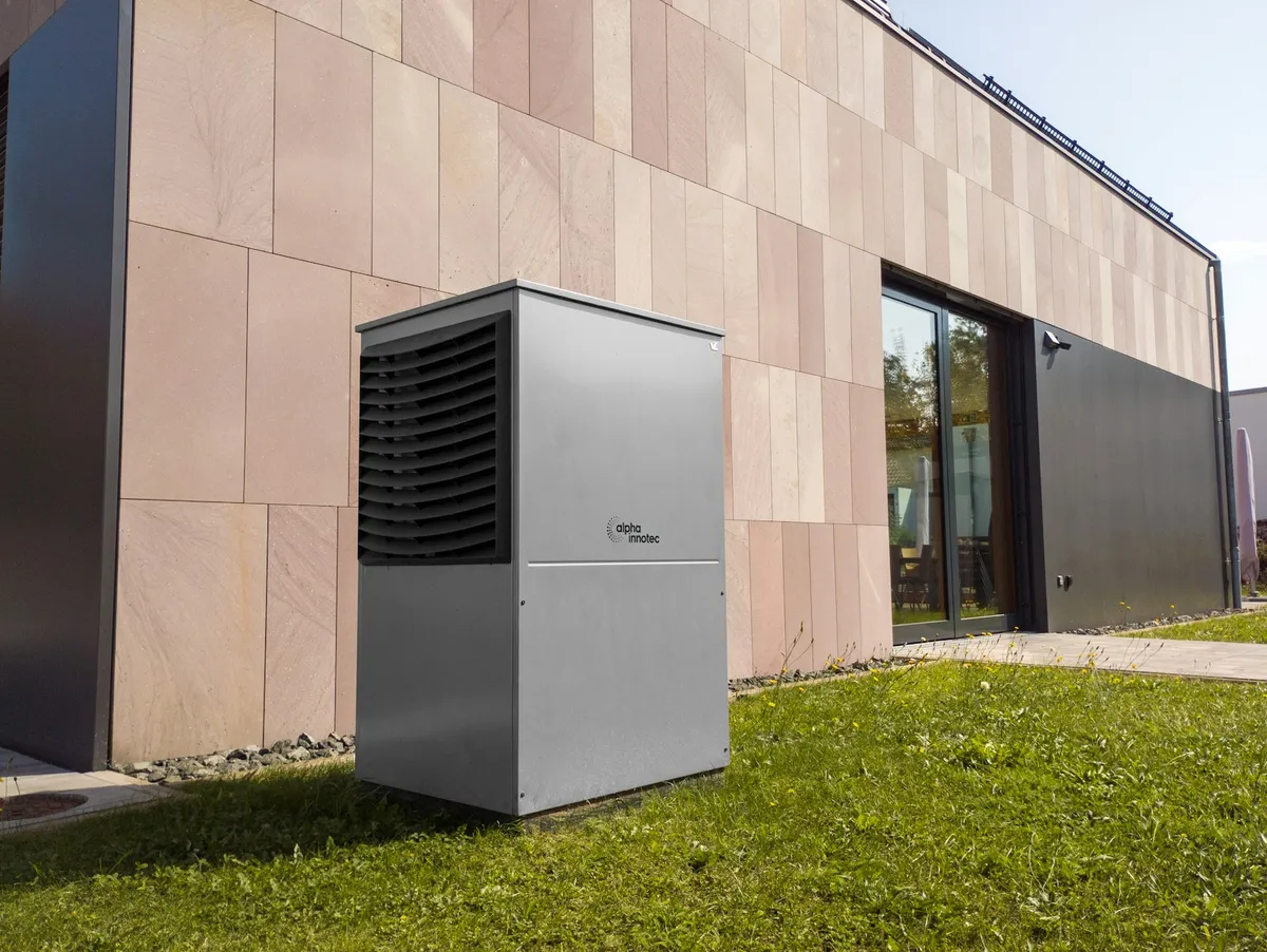 Modern outdoor AC condenser unit beside a stucco home with a sunny grassy yard, representing a well-maintained HVAC system in Cape Coral FL