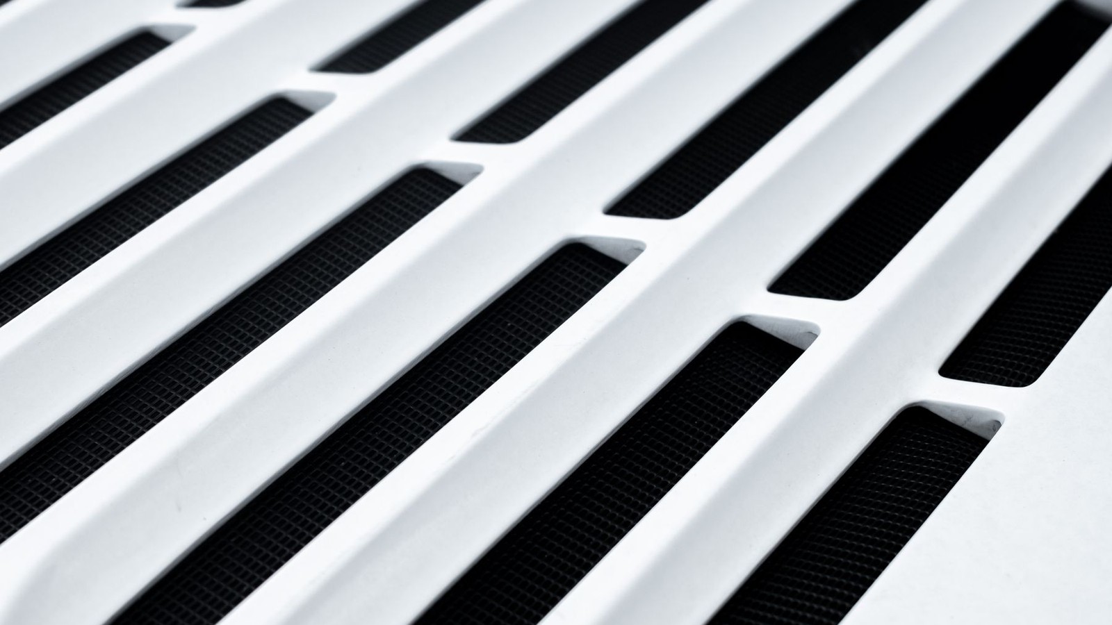 Close-up of a white return air vent grille in a home ceiling