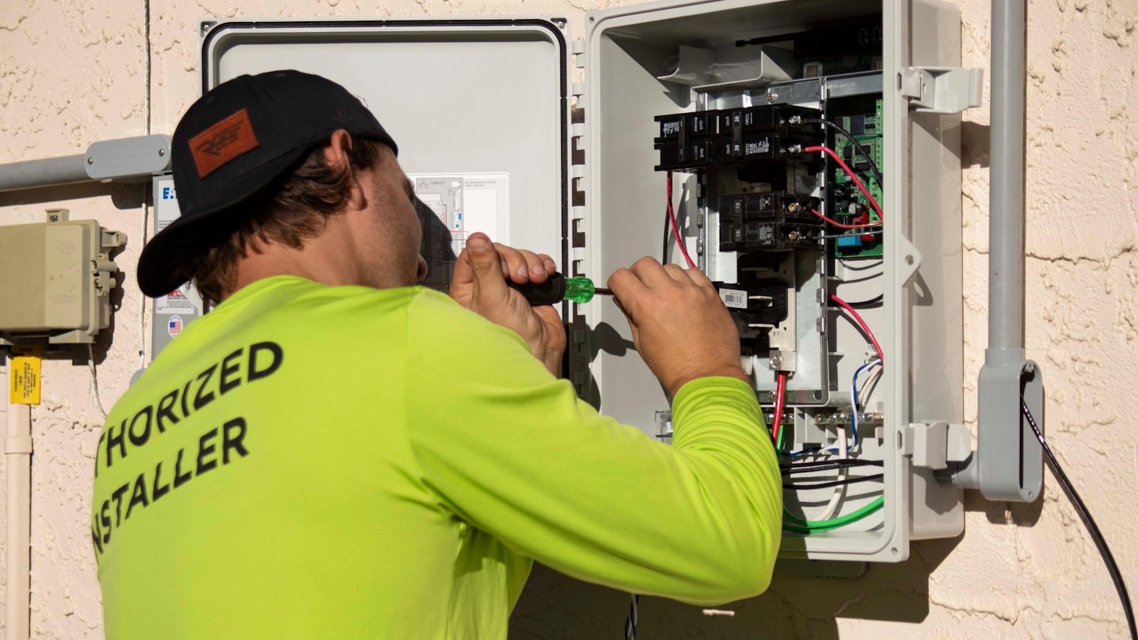 HVAC technician testing electrical components inside an outdoor disconnect box on a Florida home