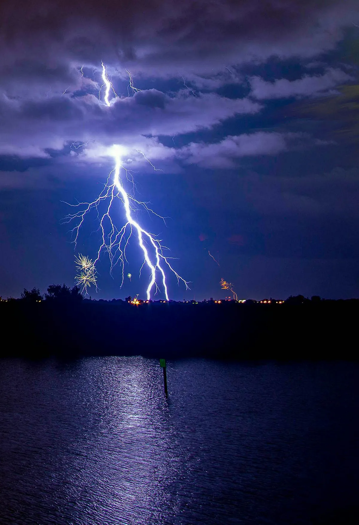Lightning bolts striking over a Florida waterway at night during a summer thunderstorm