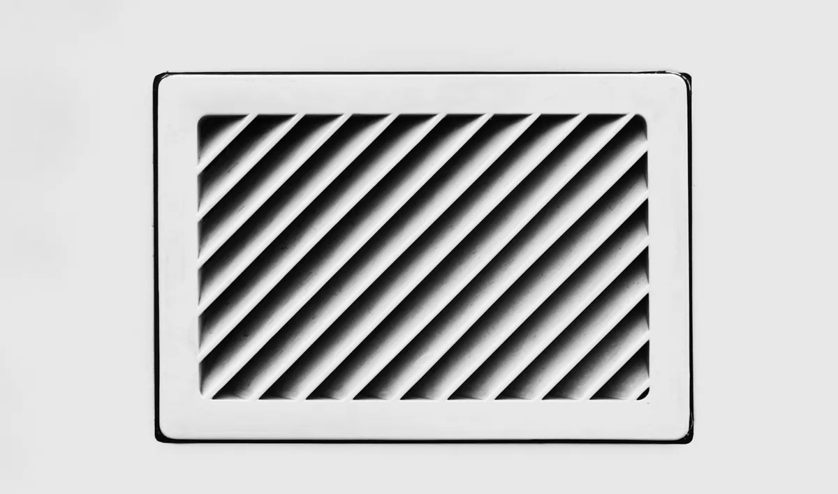 Close-up of a white rectangular HVAC supply air vent register