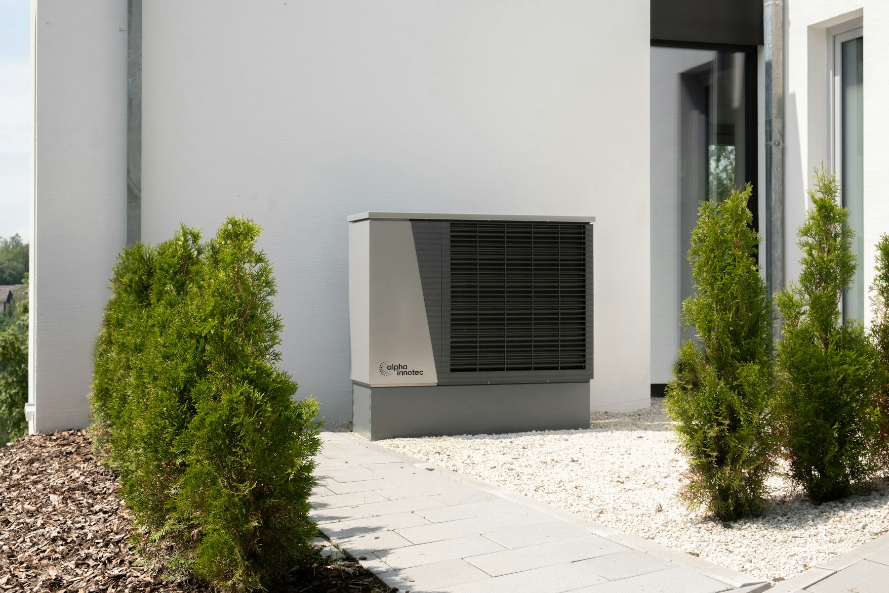 Outdoor residential air conditioning condenser unit beside a home, representing an AC system that may need emergency service