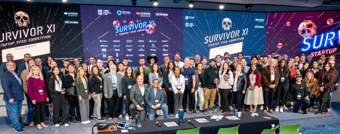 Large group photo of TCVN Survivor XI Startup Pitch Competition participants, judges, founders, and organizers on stage at the Cove at UC Irvine, with Octane, TCVN, and Orange County Innovation Week branding visible