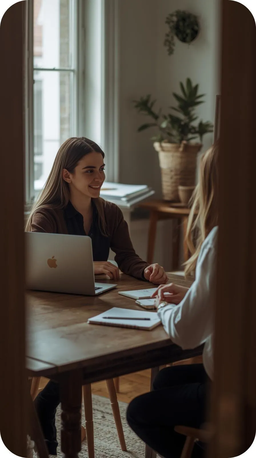 Women siting a table with a laptop and notebooks