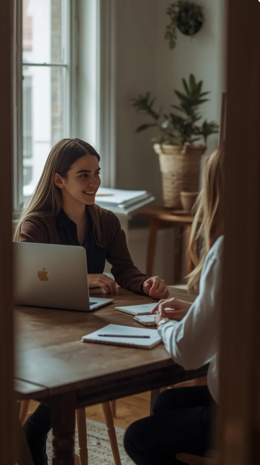 Women siting a table with a laptop and notebooks