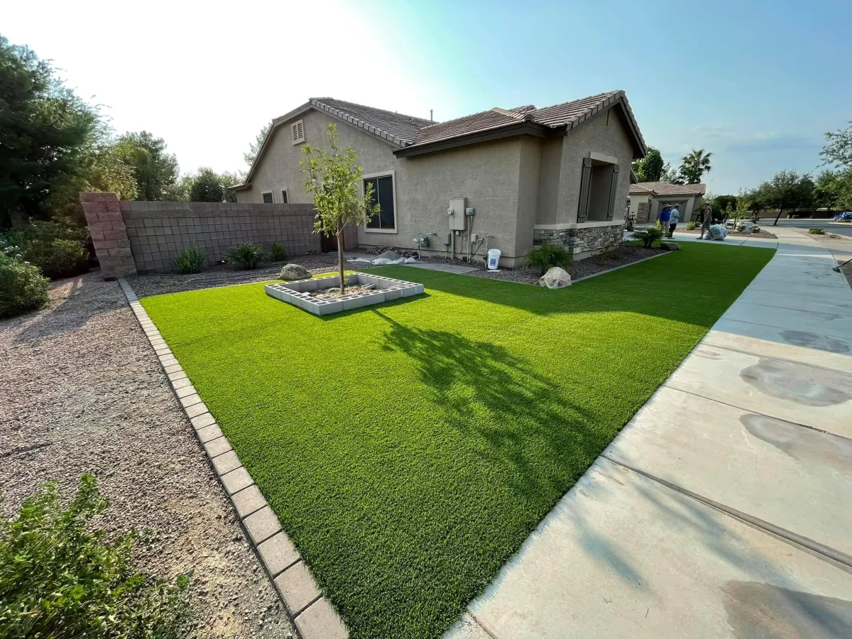 Residential front yard with professionally installed artificial grass, featuring a clean and low-maintenance landscaping design.