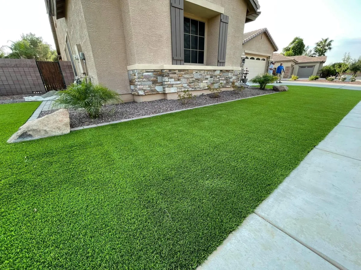 Artificial grass installation in a residential backyard, providing a low-maintenance, green outdoor space.