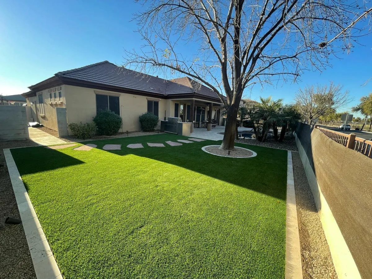 Artificial grass installation in a residential backyard, providing a low-maintenance, green outdoor space.