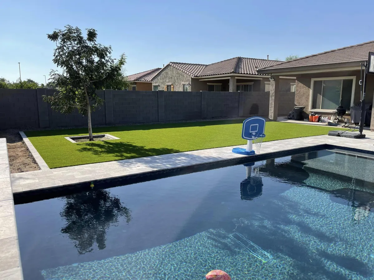 Artificial grass installation in a residential backyard, providing a low-maintenance, green outdoor space.