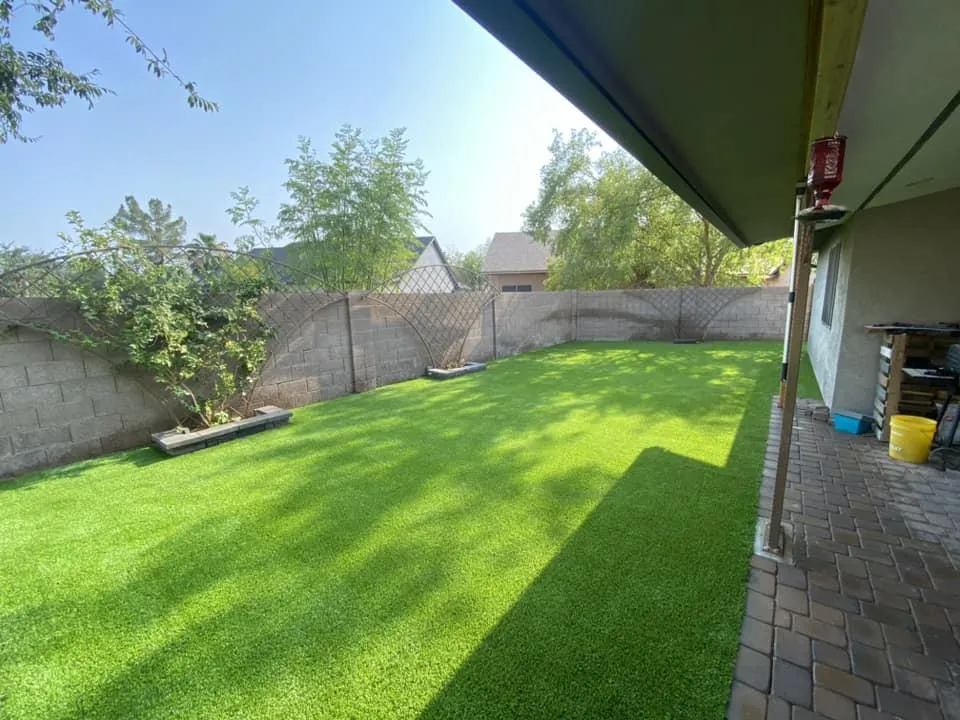 Artificial grass installation in a residential backyard, providing a low-maintenance, green outdoor space.