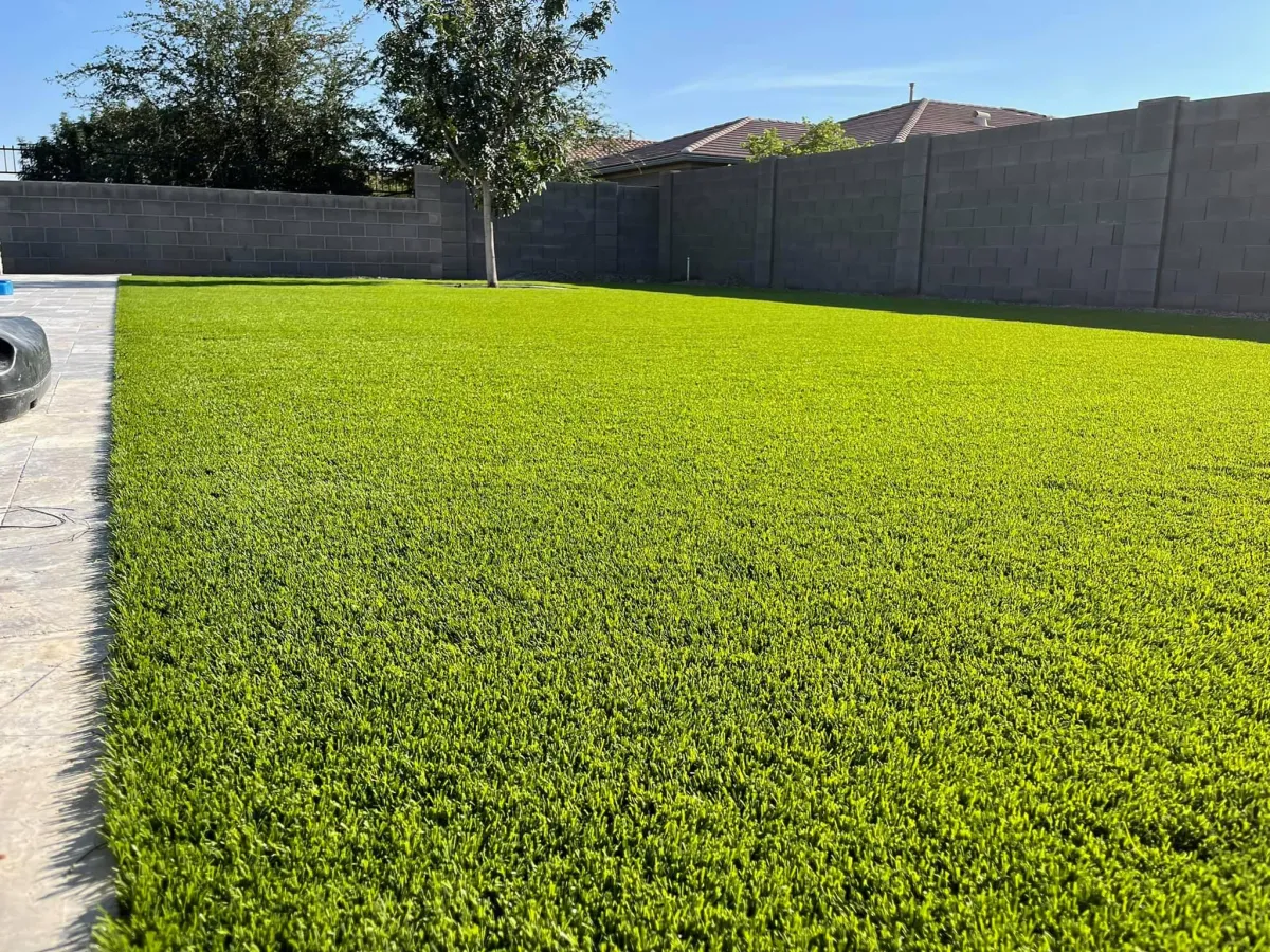 Artificial grass installation in a residential backyard, providing a low-maintenance, green outdoor space.