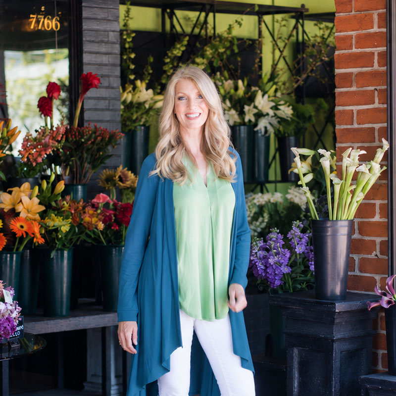 Kelly Rudolph, Inner Power Coach, smiling among fresh flowers