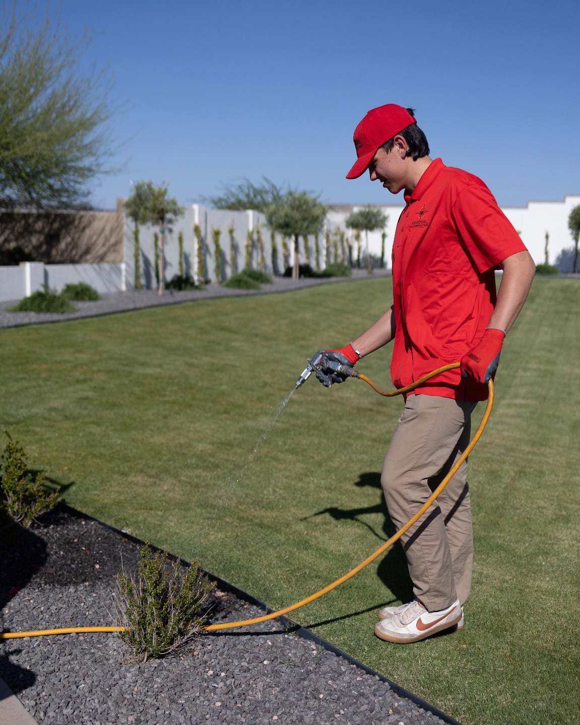 Arsenal Pest Control technician treating the exterior of a Chandler home