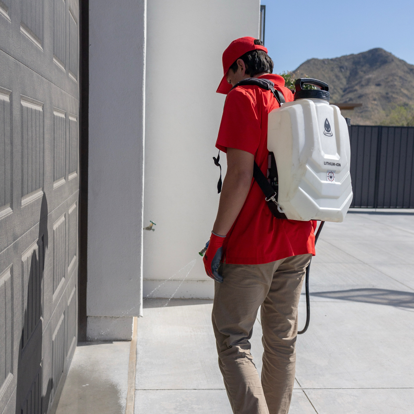 Arsenal Pest Control technician inspecting the exterior of a Chandler home