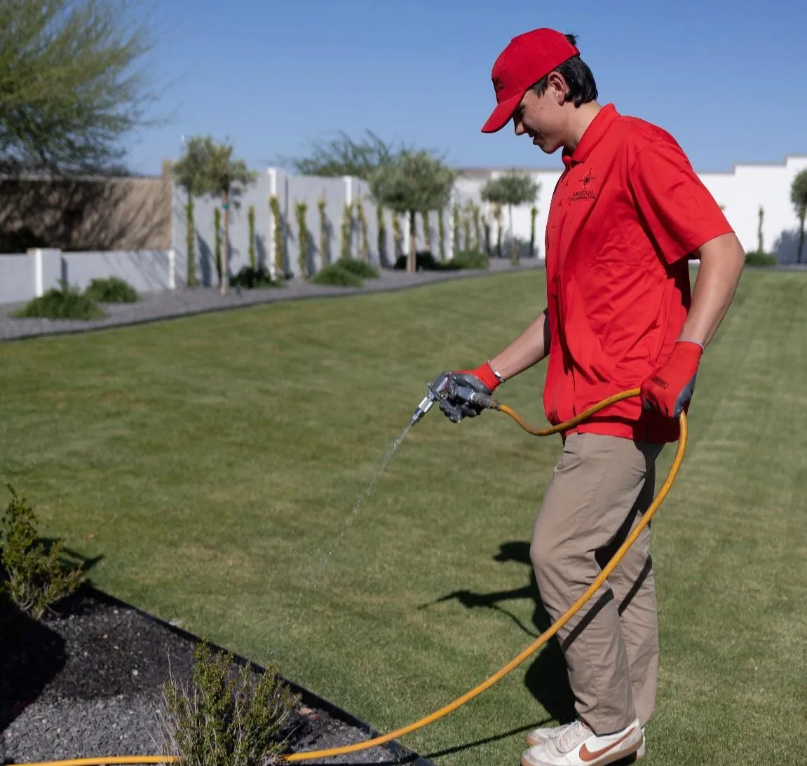 Arsenal Pest Control technician inspecting the exterior of a Chandler home