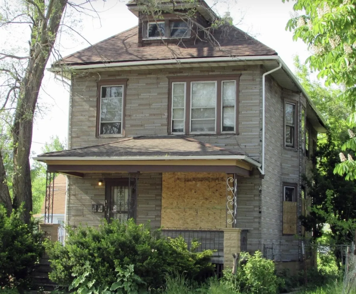 man in blue dress shirt sitting on rolling chair inside room with monitors