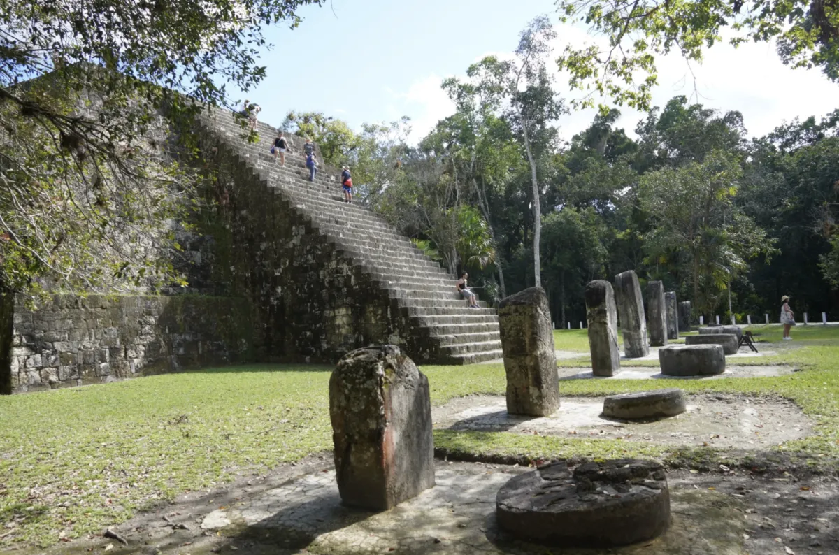 People climbing the steps of an ancient Mayan ruin at the Tikal site in the Petén region of Guatemala.