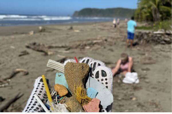 A beach is littered with plastic and trash, demonstrating why ecotourism in Guatemala is important