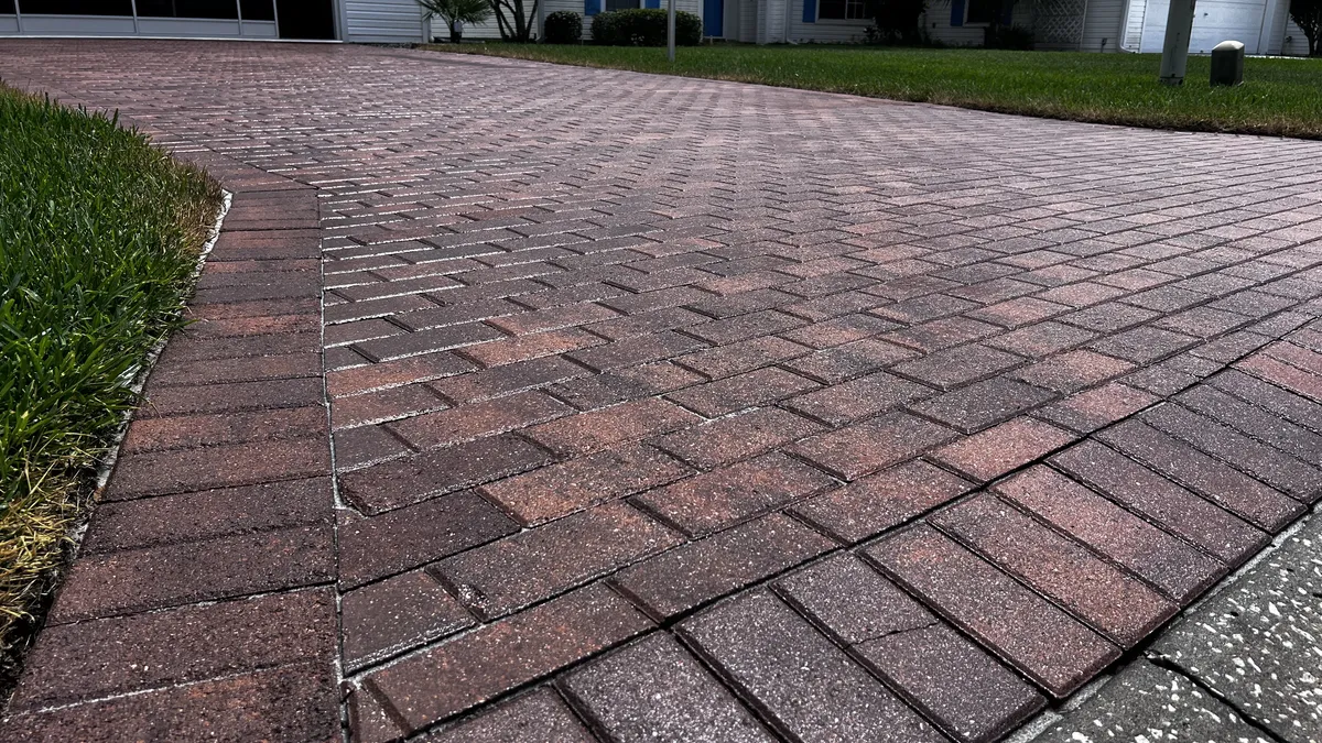 Open brick paver driveway with vehicles and furniture cleared from the surface
