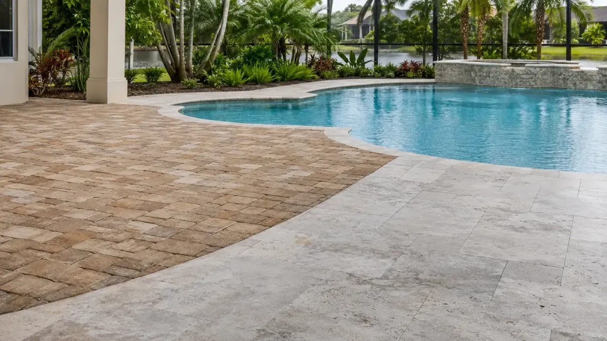 Florida swimming pool bordered by clean sealed brick pavers and light natural stone with restrained finishes.