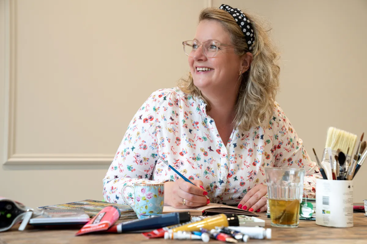 anna working on a table on a painting