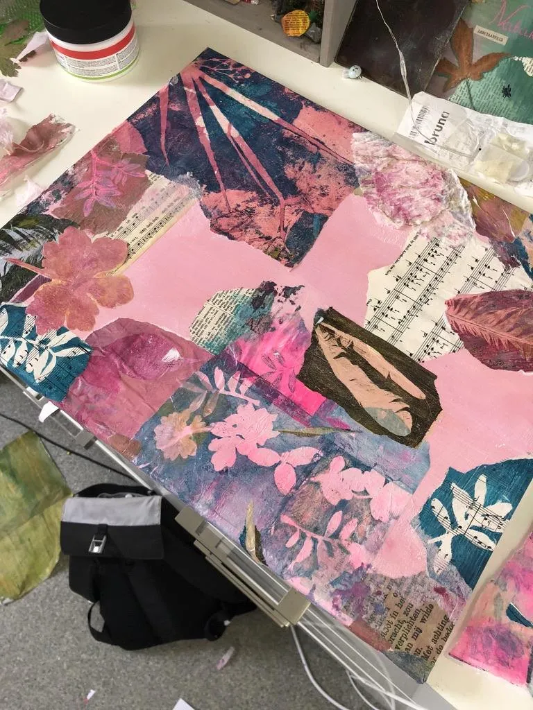 layersof diverend papers on a canvas in proress with pink and blue and purple botanical shapes