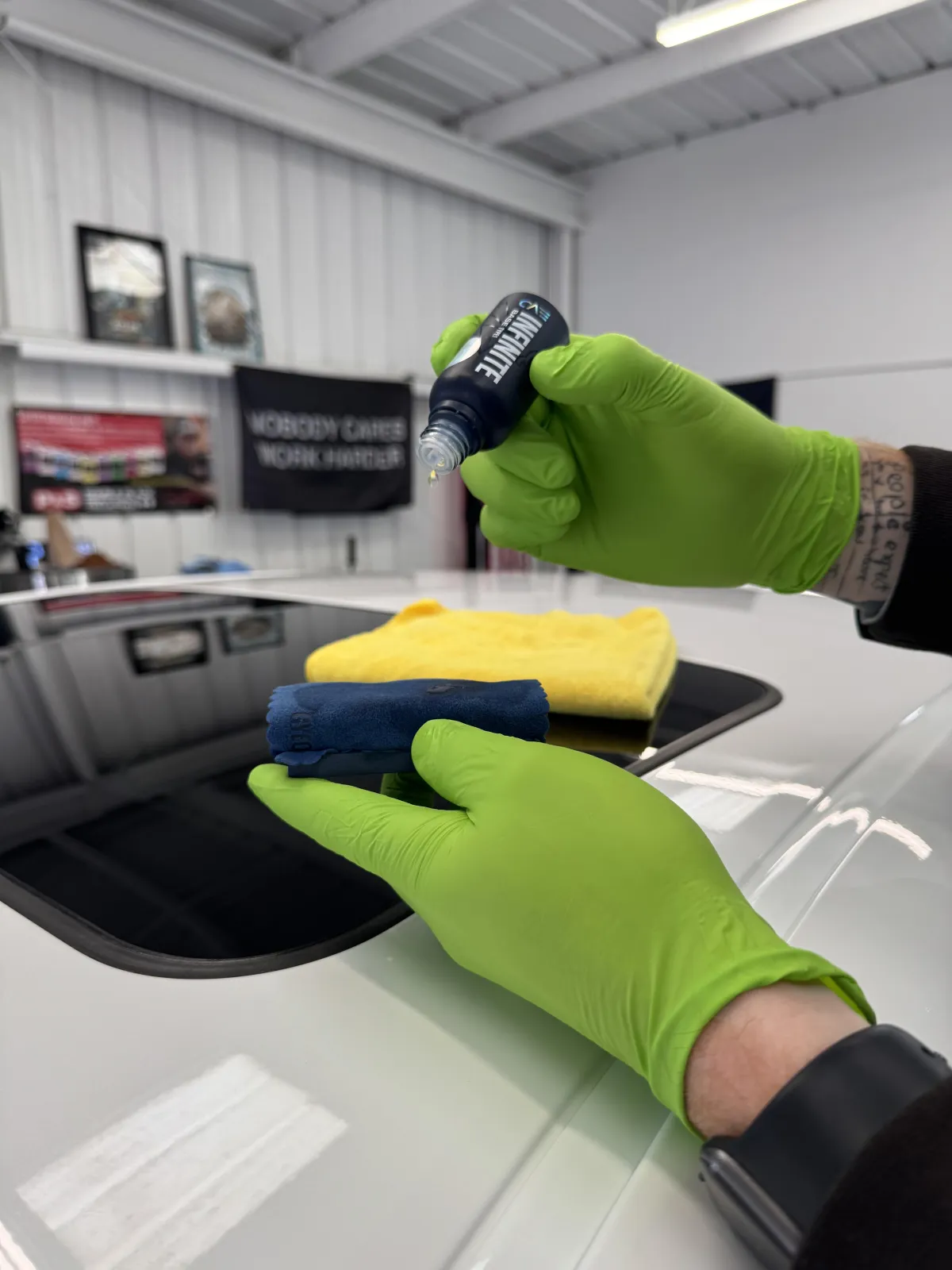 alt="Technician applying Gyeon ceramic coating to car hood in Grover Beach studio"