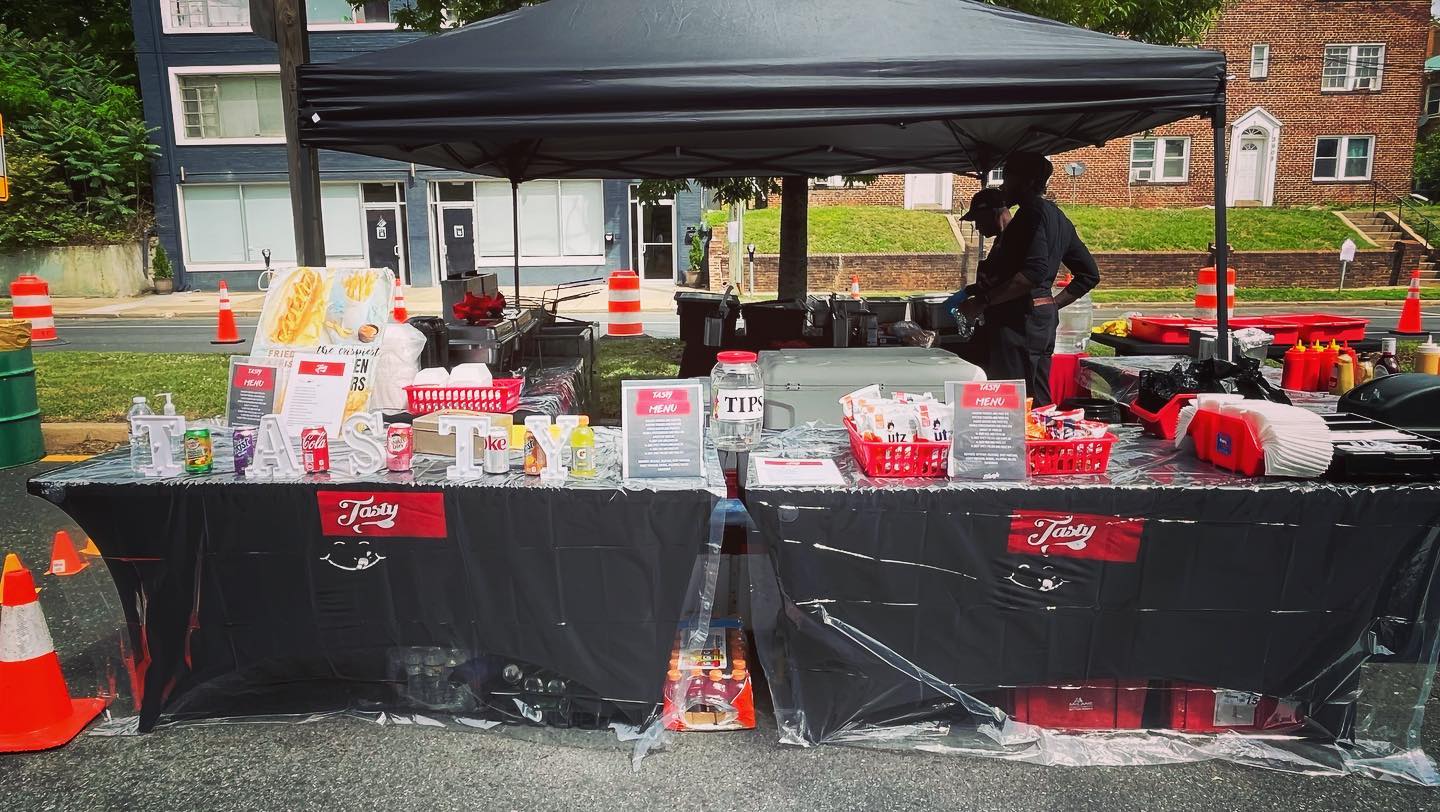 Tastys Temptation outdoor catering setup with food stations, serving equipment, and event supplies ready for guests