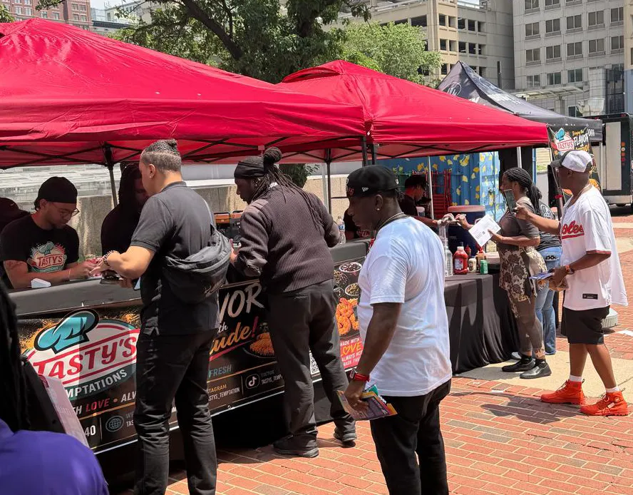 Tastys Temptation food station serving customers at an outdoor event
