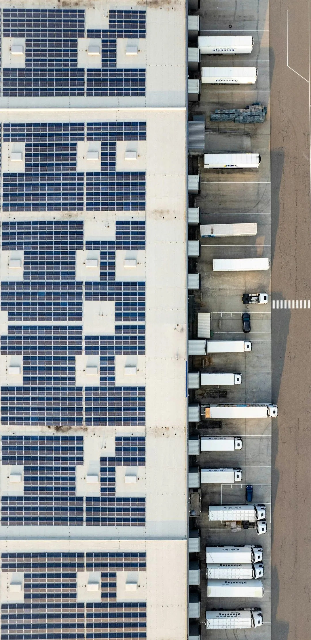Electric truck fleet charging at a logistics depot representing peak demand and load management decisions for warehouse owners in 2026