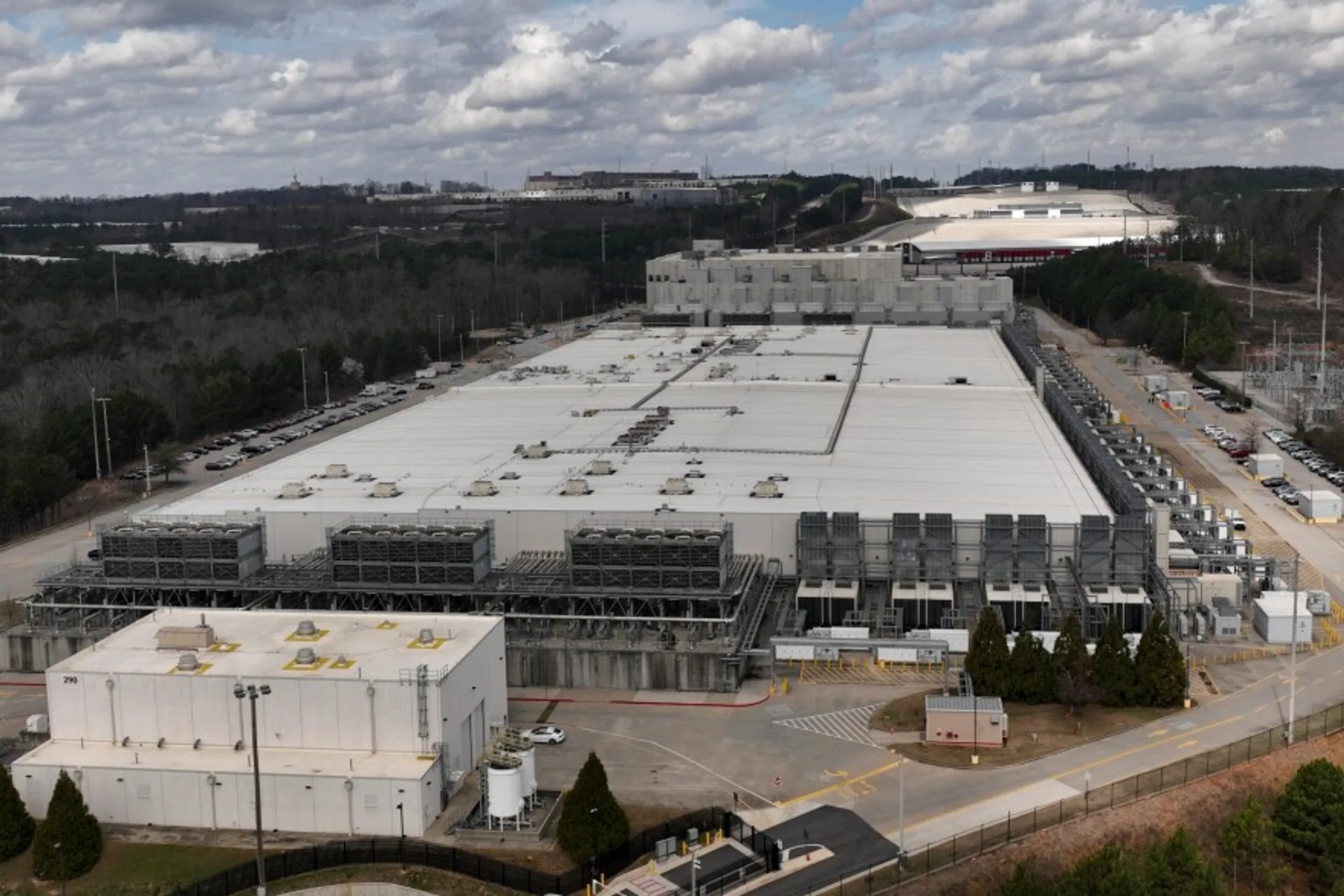  Transmission infrastructure beside a data center, illustrating the fight over who pays for grid capacity.