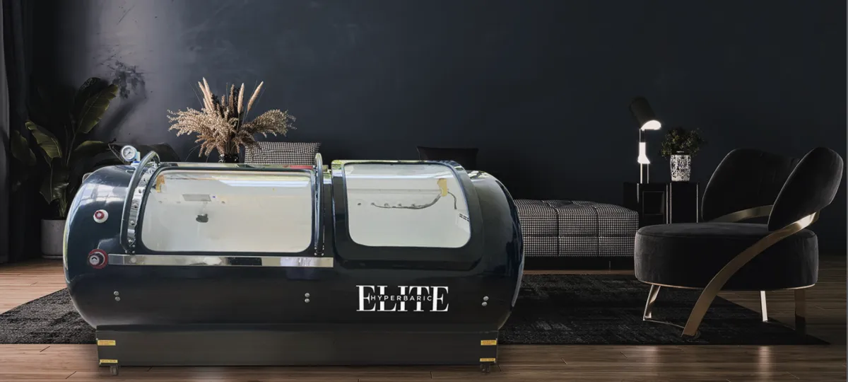 A modern hyperbaric oxygen chamber in a modern space with a chair next to it simulating what a HBOT Chamber would look like in your home or office