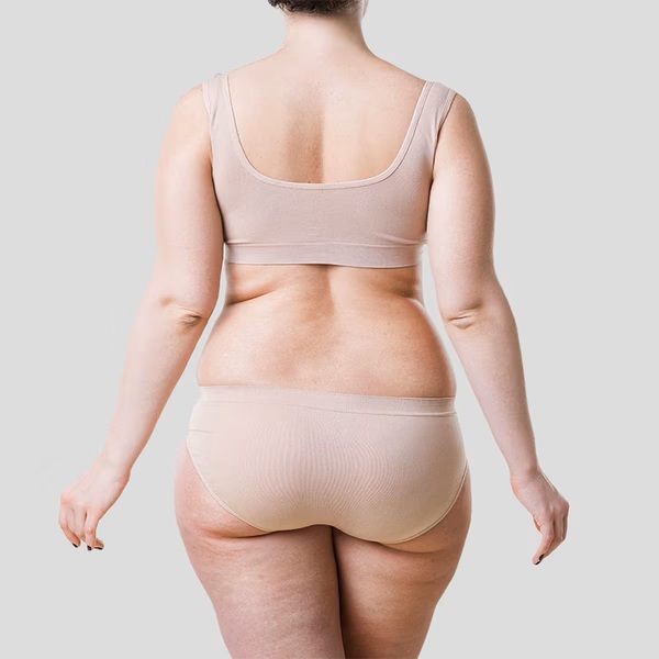 person holding clear glass bottle