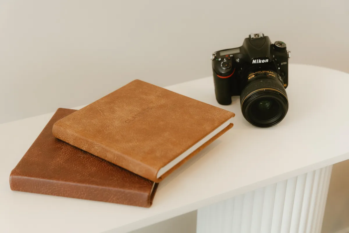 stack of client albums with camera